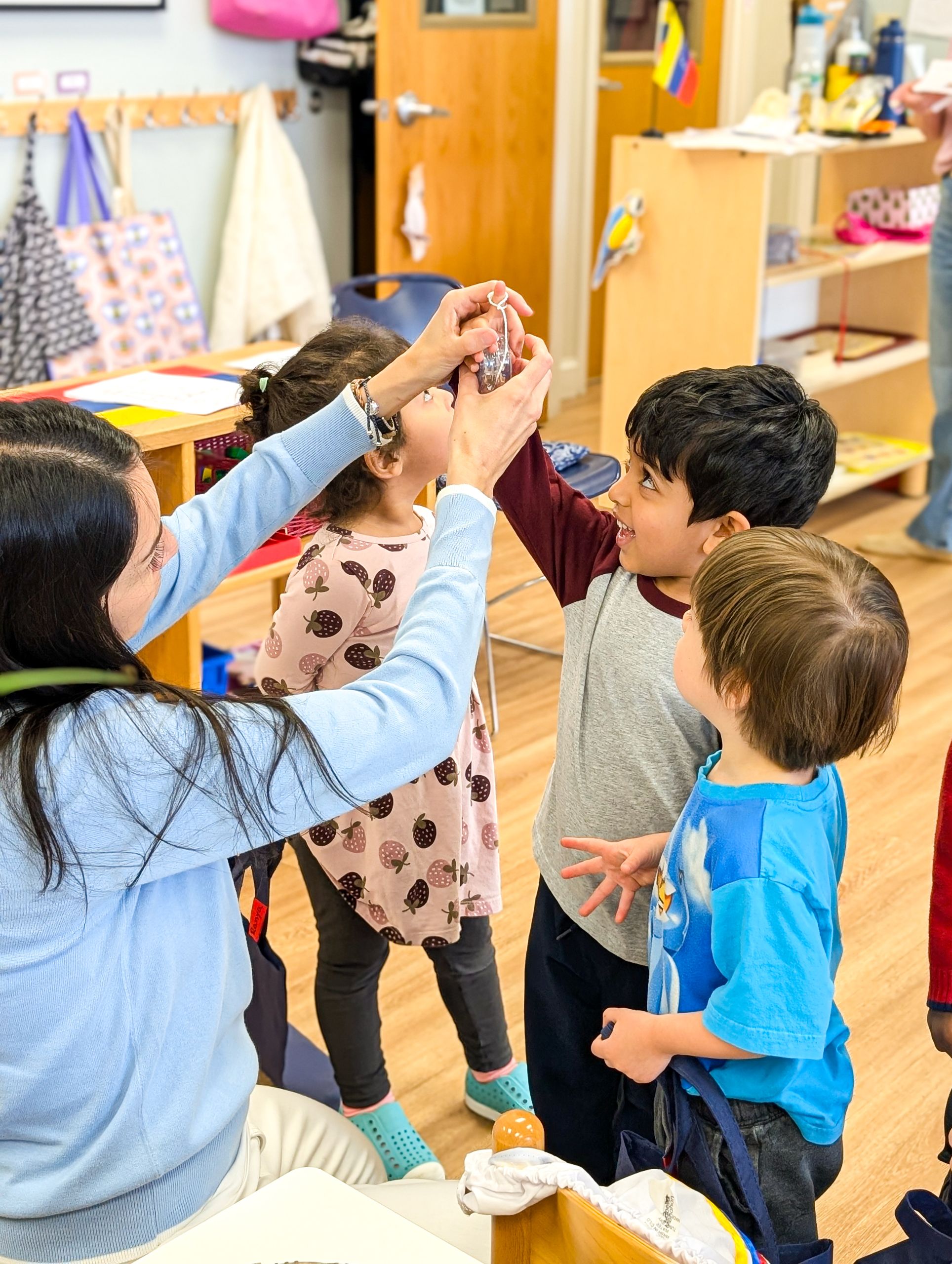 PXL_20260413_135802338.PORTRAIT Group of primary classroom children exploring a Yo-Yo with adult guidance